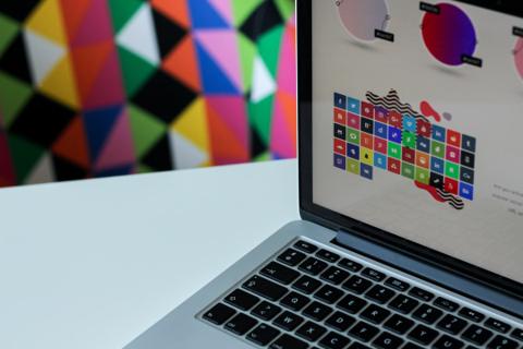 Laptop on workspace showing colorful abstract design